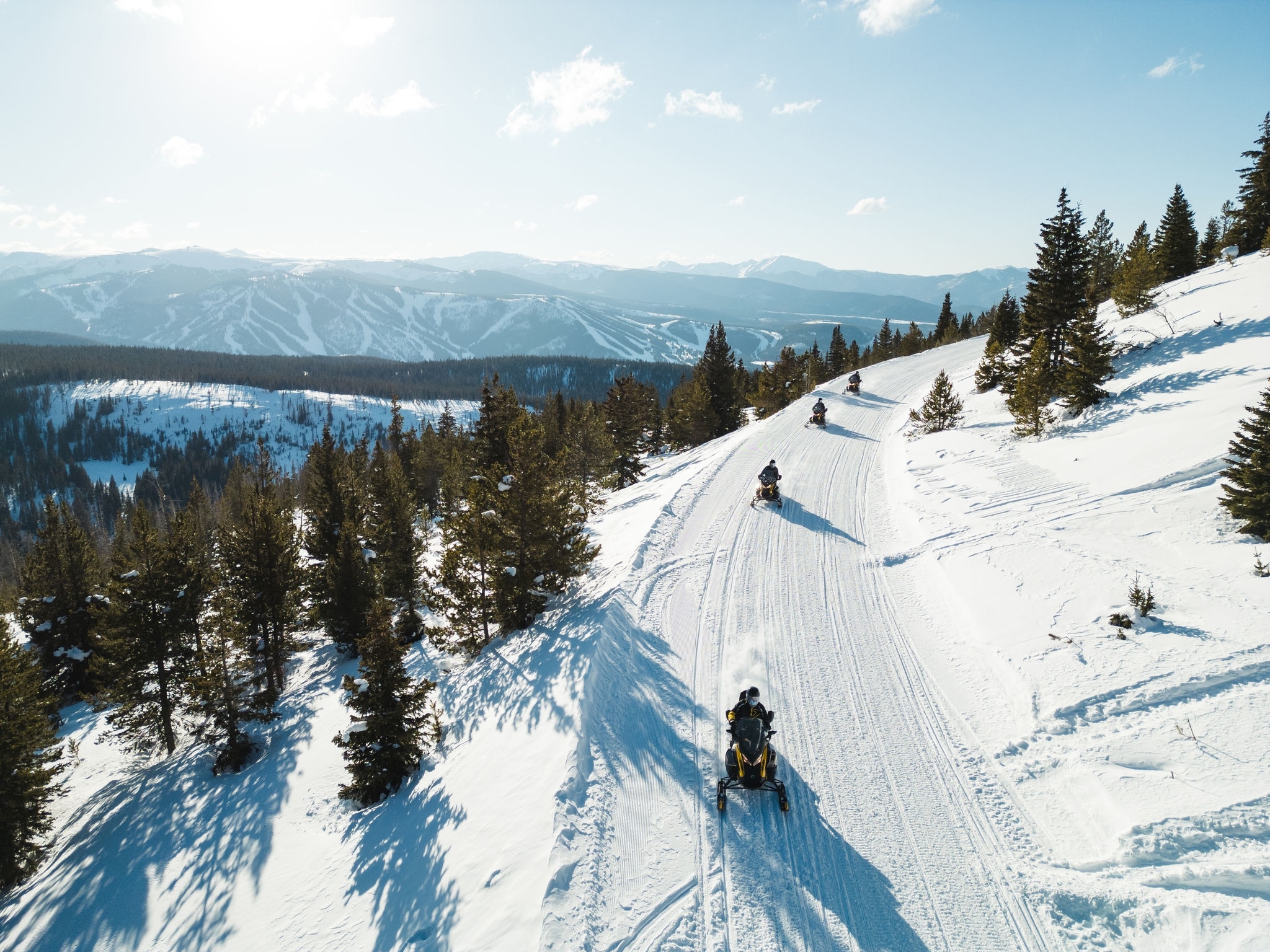 Groupe de motoneigistes sur une colline enneigée