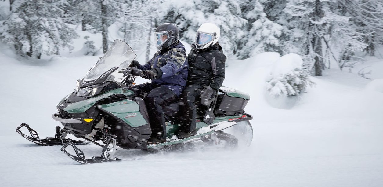 Motoneige Ski-Doo en randonnée dans une forêt enneigée