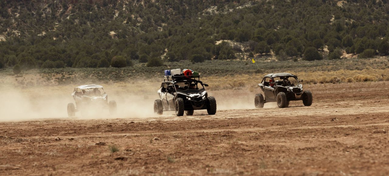 Trois véhicules côte-à-côte de Can-Am en excursion dans le désert