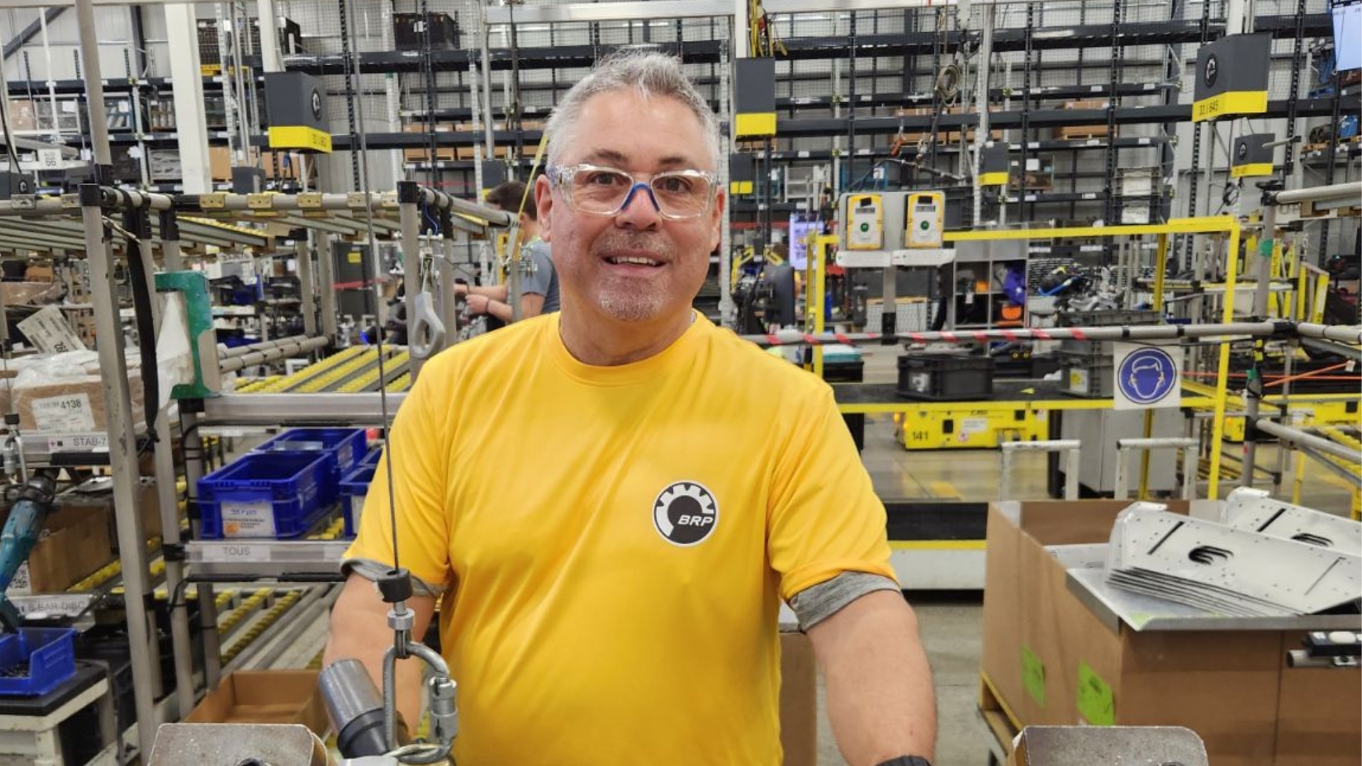Un empleado con una camiseta amarilla de la iniciativa Ride out en una instalación.