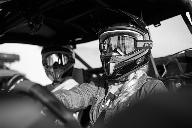 Two riders sitting in a Can-Am Side-by-side (SxS) vehicle