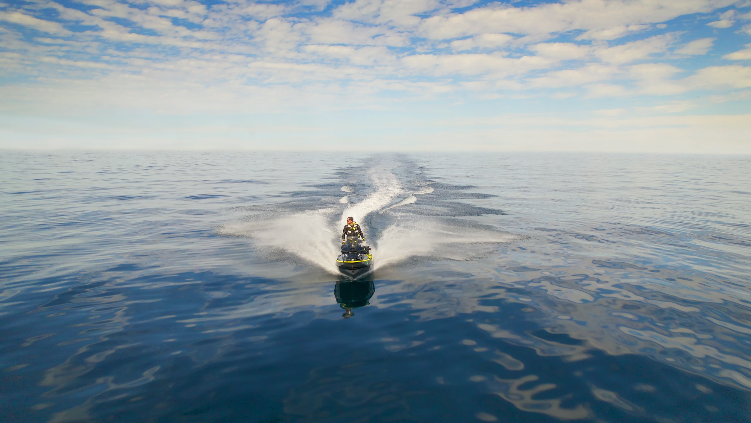 Man riding a Sea-Doo personal watercraft in the middle of a body of water