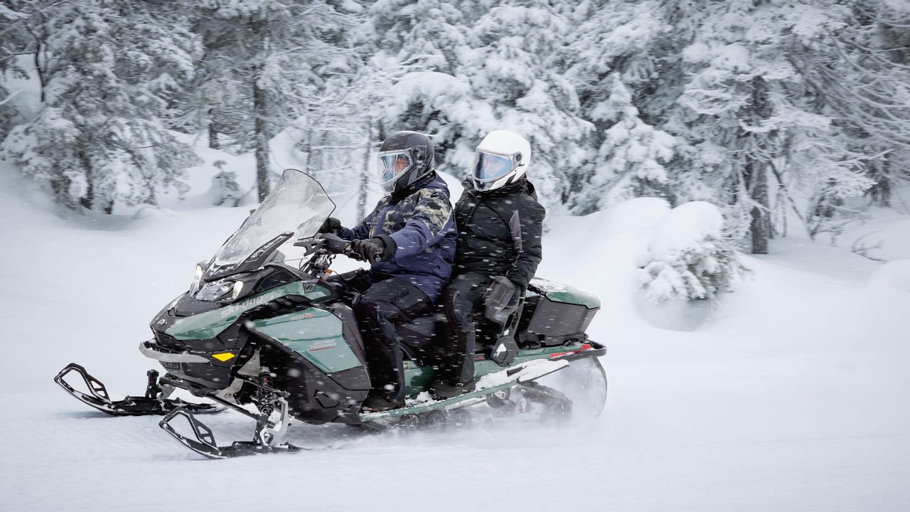 Motoneige Ski-Doo en randonnée dans une forêt enneigée