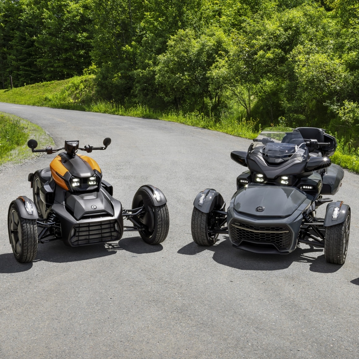 Two Can-Am 3-wheel vehicles parked on asphalt
