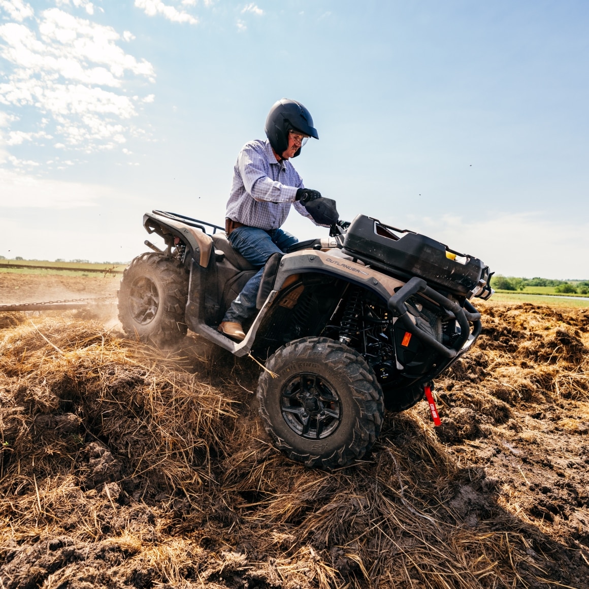 A man riding his Can-Am ATV down a small hill