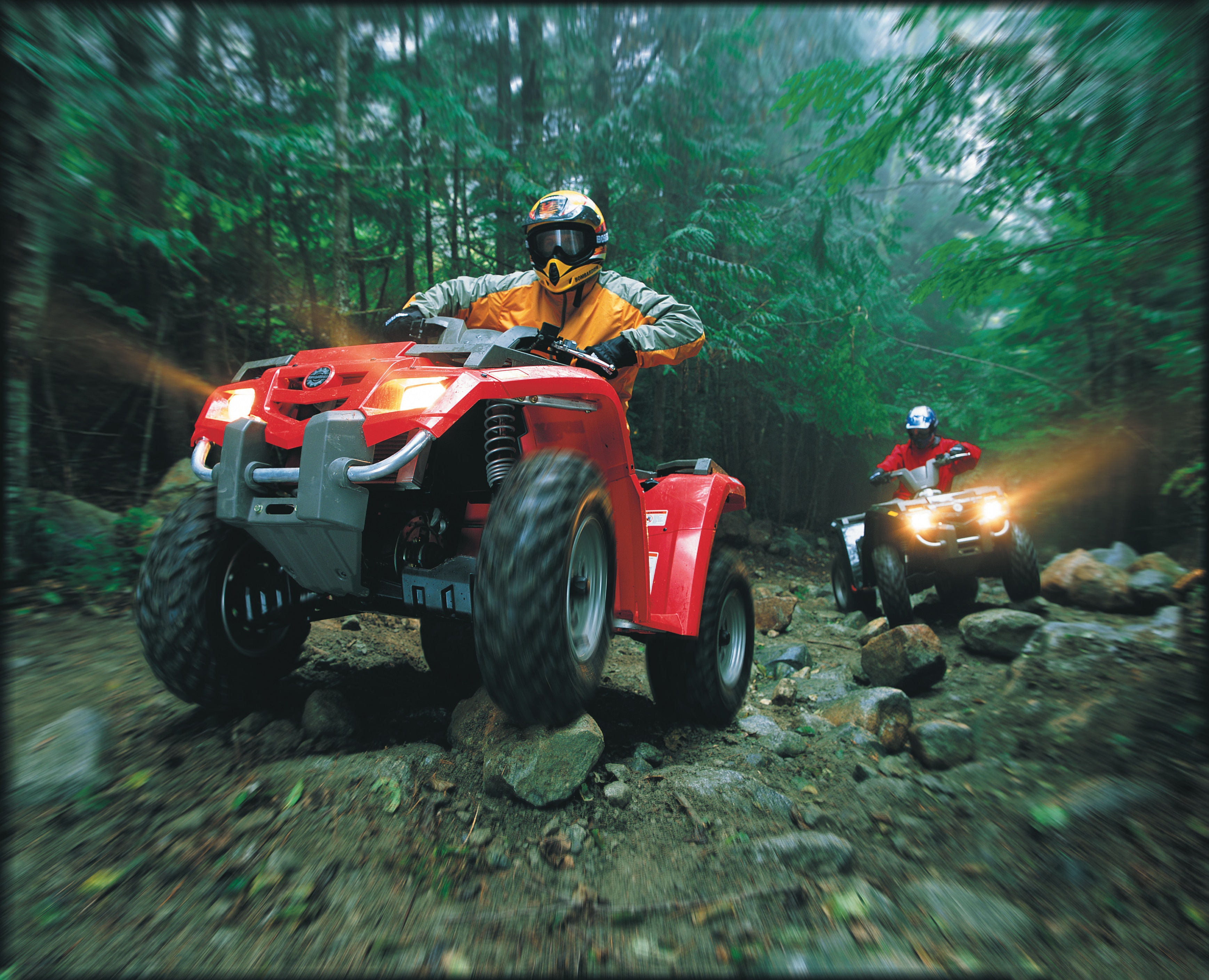 Two Can-Am ATV riding in a rocky forest