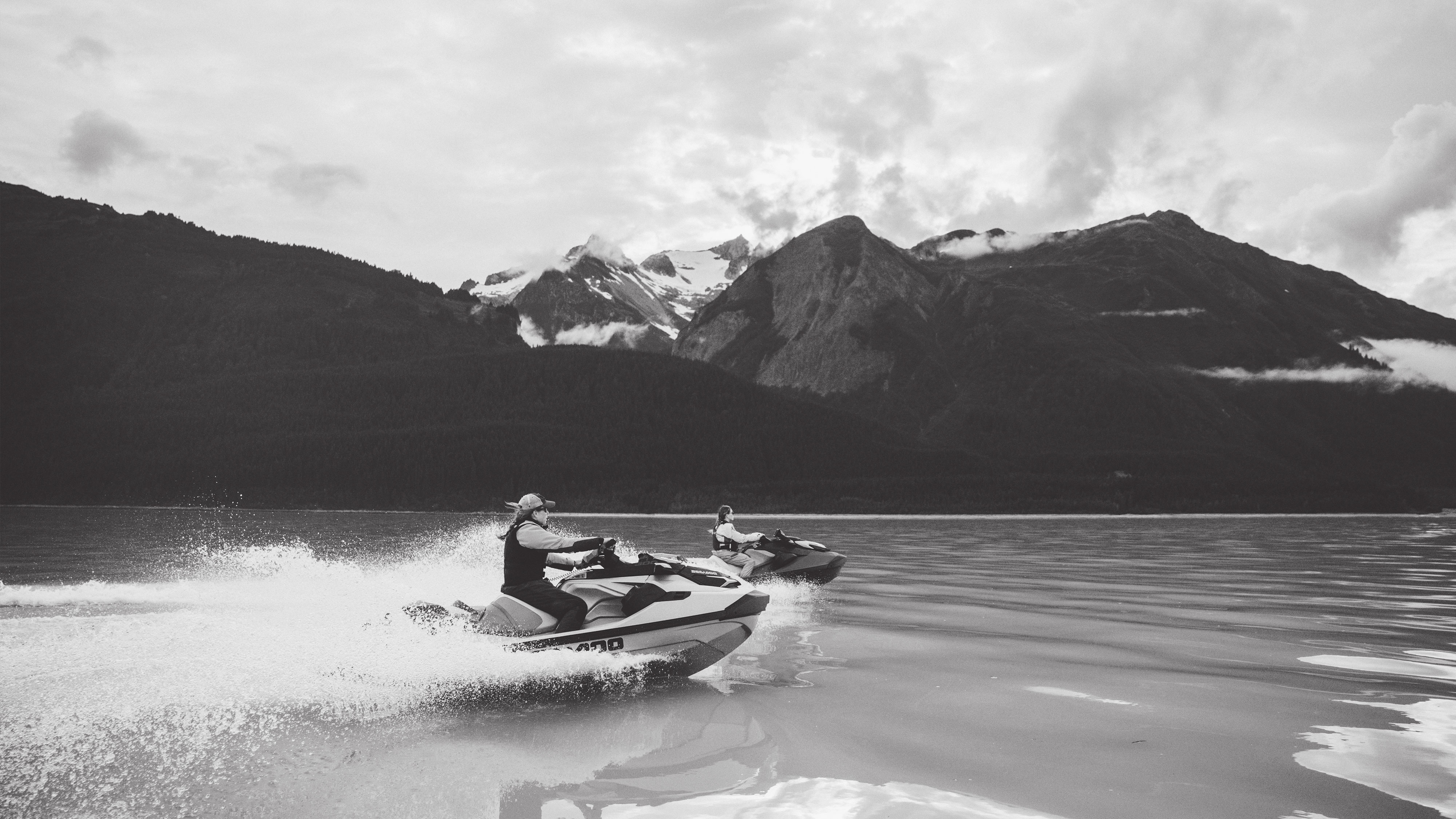 Two Sea-Doo personal watercrafts riding on a body of water