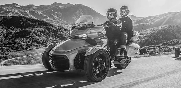 Two people riding a Can-Am Spyder RT 3-wheel vehicle