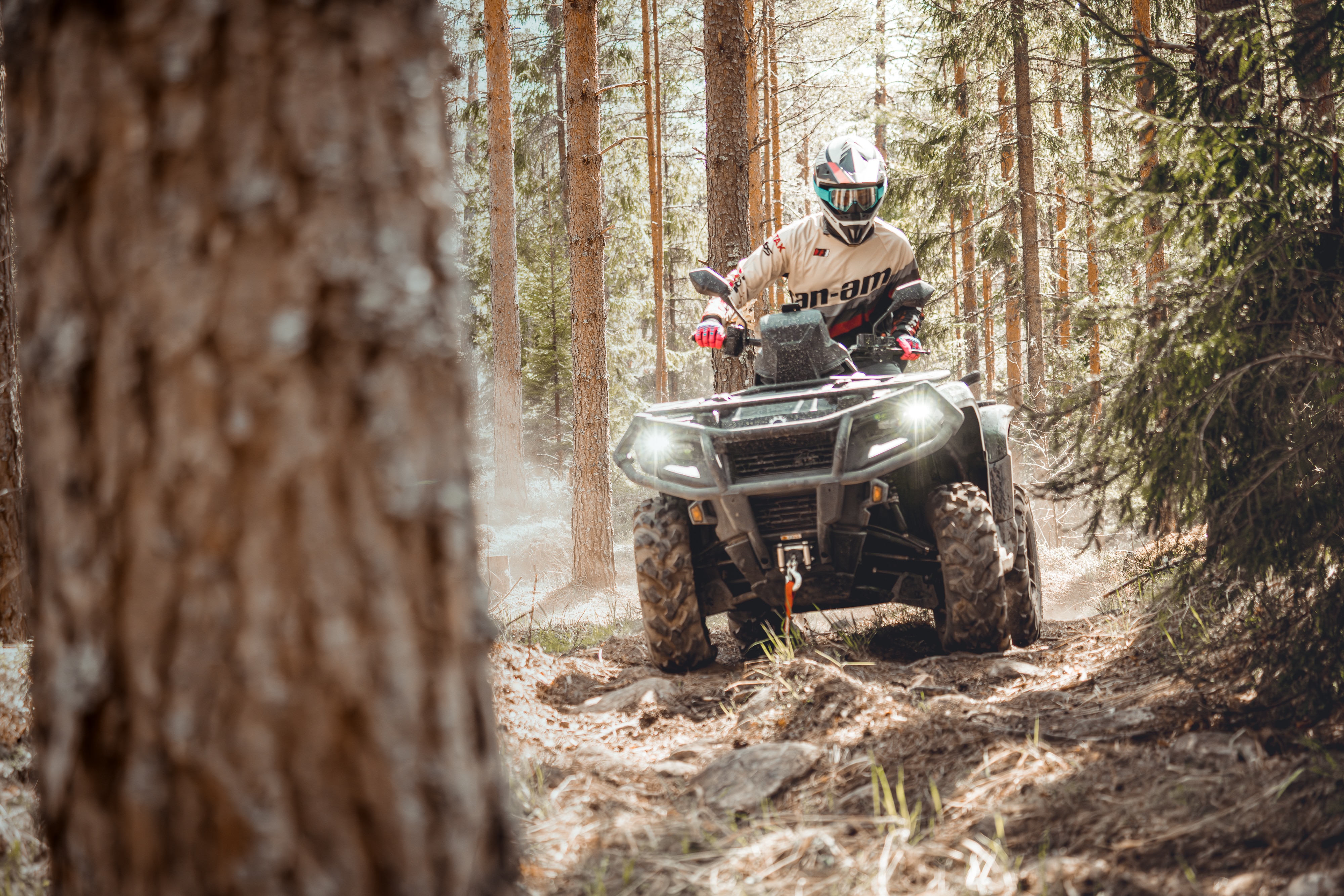 Outdoor enthusiast riding a Can-Am ATV in a forest