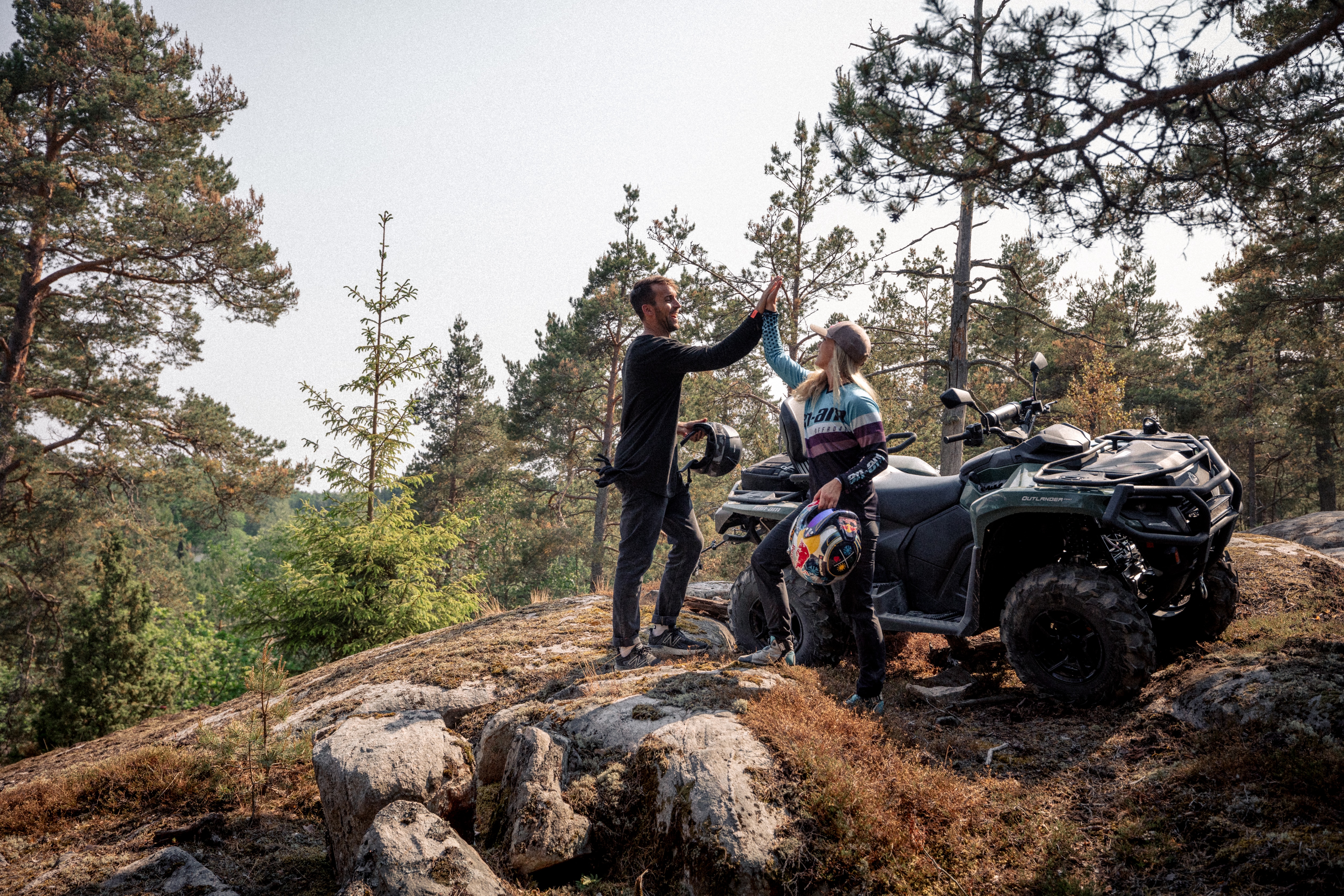 Two off-road riders next to a Can-Am ATV