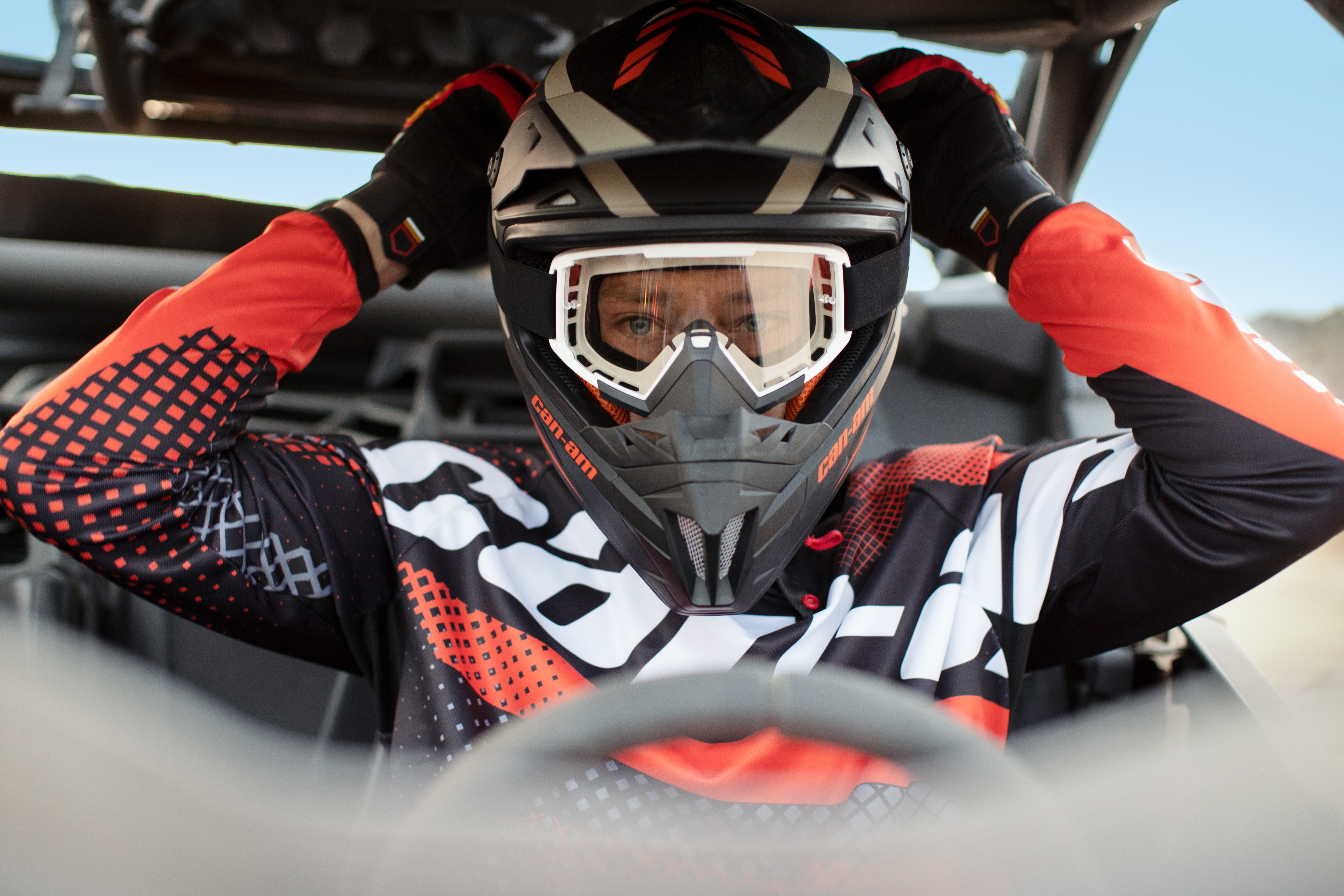 Woman about to ride off in a Can-Am Off-Road SxS vehicle