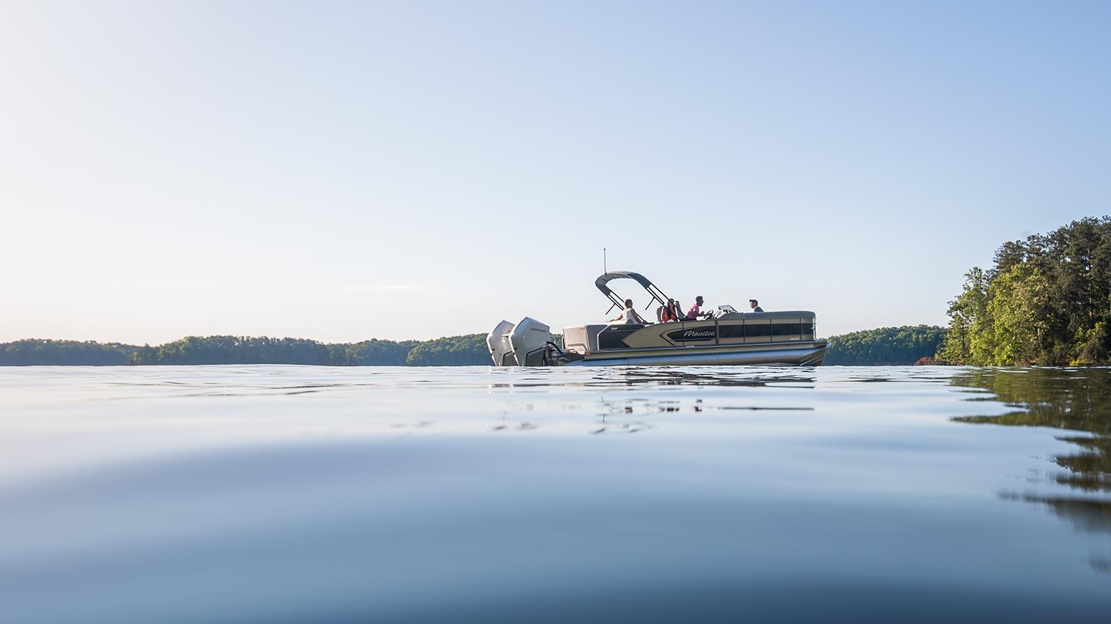 Manitou pontoon boat idle on a body of water 